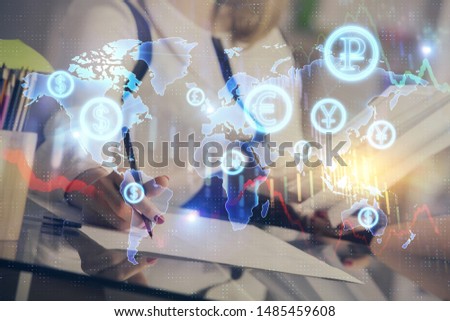 A woman hands writing information about stock market in notepad. Forex chart holograms in front. Concept of research.