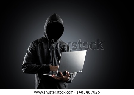 Cybercrime, hacking and technology crime. no face hacker with laptop on black background with clipping path. Royalty-Free Stock Photo #1485489026