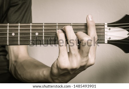 Guitar Player Hand or Musician Hand in F Major Chord on Acoustic Guitar String with soft natural light in close up view Royalty-Free Stock Photo #1485493901