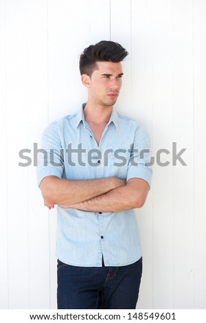 Portrait of an attractive male standing outdoors with arms crossed on white background