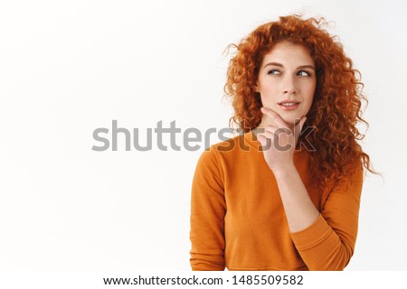 Hmm interesting. Curious cunning good-looking redhead girl planning perfect scheme, rub chin, squinting suspicious and thoughtful peek left, thinking, pondering between nice choices Royalty-Free Stock Photo #1485509582