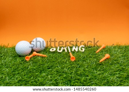 Golf ball with tees are on green on Sun set background.
