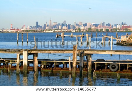 View of Manhattan skyline behind an old fishing pier.