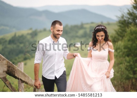 Beautiful young wedding couple standing on the green slope, hill. Groom and bride in Carpathian mountains