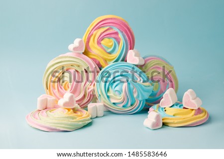 Pink marshmallow in heart shape and rainbow merengue on blue. Sweet candy for love theme on Valentine concept in vintage style. Pastel color dessert