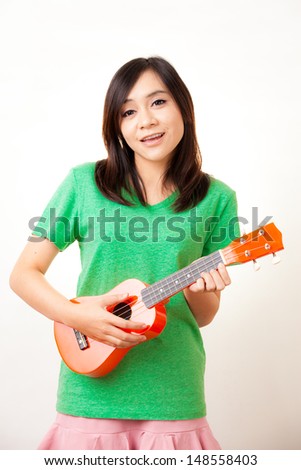 Asian woman enjoy singing with her ukulele