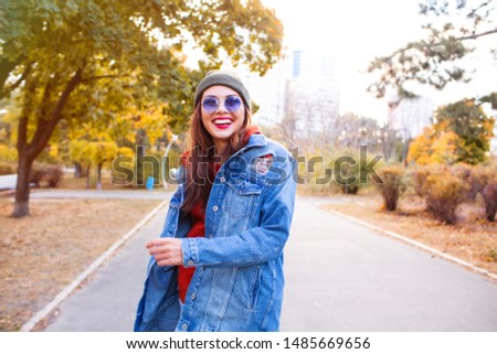 Happy girl jumping in a park. portrait of stylish smiling happy  woman in headwear walking in the park outdoor, attractive, sunny, summer fashion trend, shirt, traveler, sunglasses, jeans coat.