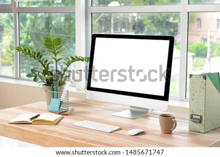 Stylish workplace with modern computer near window