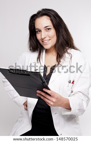 Portrait of a friendly female doctor writing on a notepad