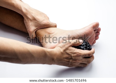Foot massage using rolling ball isolated on white background. Help perevent and heal wrist pain, reduce muscle pain and recover common injury  can be used for sport article Royalty-Free Stock Photo #1485701696