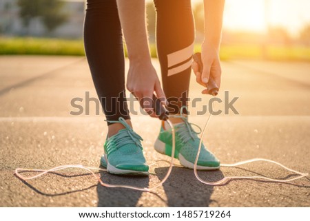Sportswoman is preparing to do cardio exercises with skipping rope outdoors  Royalty-Free Stock Photo #1485719264