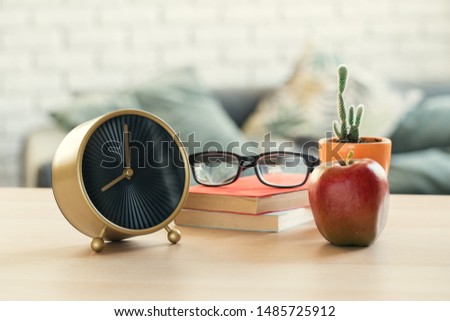 It's time for school. Vintage alarm clock and apple on wooden desk