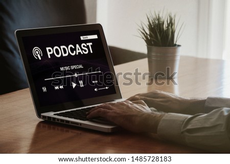 Man listening podcast while work in the office. Podcast website in the laptop screen.