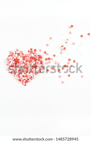 Valentine's Day. Creative holiday concept of love made from broken red heart shaped flying sweet confetti. Valentines day top view on white background.
