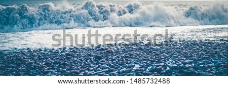 Sea wave surf. Sea waves with a lot of sea foam. In the foreground on a pebble beach. The element of water, excitement, bad weather.Selective focus on foam Banner