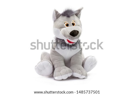 Closeup toy grey soft wolf sitting at isolated white background.