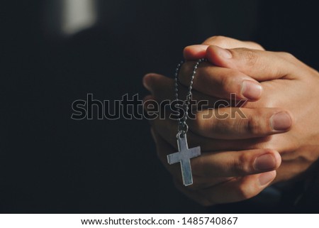 Close up hands holding Cross necklace.Pray for god blessing to wishing have a better life.Wish blessing from the coronavirus crisis
