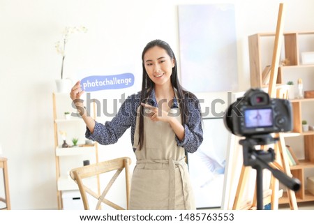 Female Asian blogger recording video in workshop