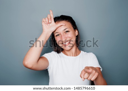 Funny woman making fun of someone with loser hand gesturing Royalty-Free Stock Photo #1485796610