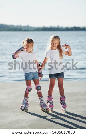 Posing for a camera. Happy female friends on roller skates. Leisure time.