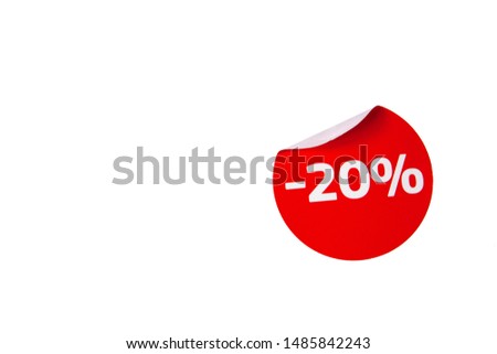 Round red discount sticker with curled edge on a white background isolated.