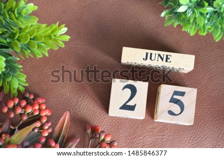 June 25. Number cube in natural concept on leather for the background