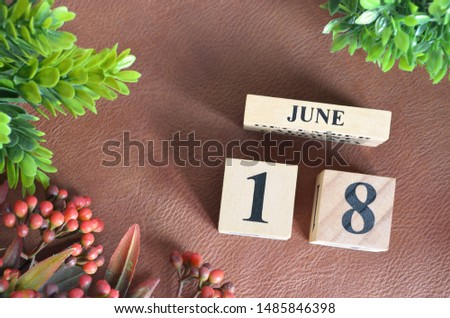 June 18. Number cube in natural concept on leather for the background