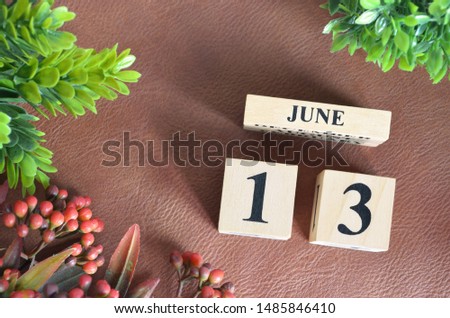 June 13. Number cube in natural concept on leather for the background