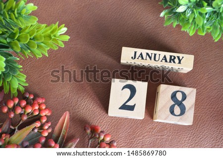 January 28. Number cube in natural concept on leather for the background