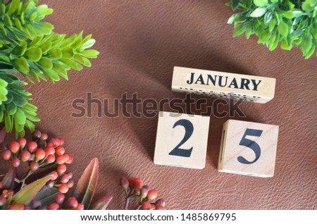 January 25. Number cube in natural concept on leather for the background
