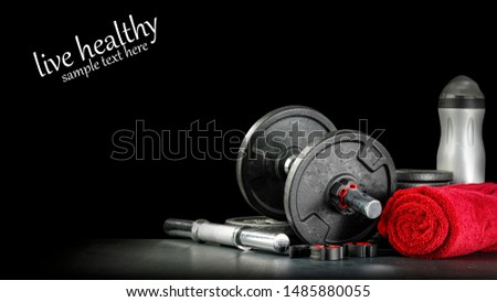 Black background of dark desk with dumbbells and free space for your text. 