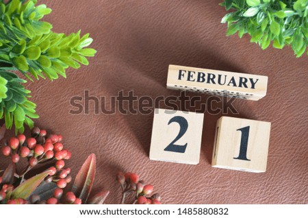 February 21. Number cube in natural concept on leather for the background