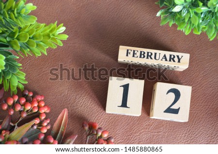 February 12. Number cube in natural concept on leather for the background