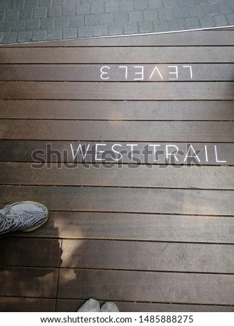 A​ neat embedded​ stainless steel​ signage on​ wooden​ floor.​ The​ modern​ signage​ design​ in​ Jewel​ Shopping​ mall, Changi​ Airport, Singapore.​​ 