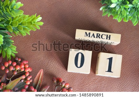 March 1. Number cube in natural concept on leather for the background