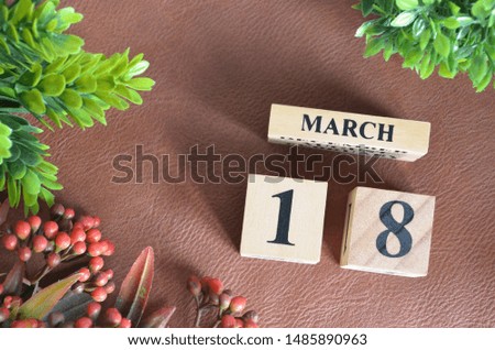 March 18. Number cube in natural concept on leather for the background