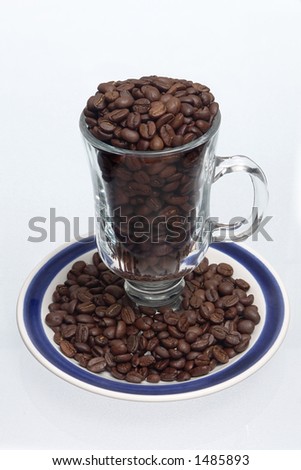 cup and dish full of coffee beans