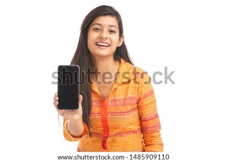 Cheerful pretty Indian young women showing smartphone