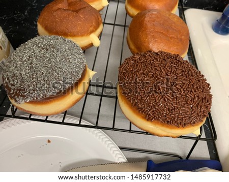 Custard donuts topped with chocolate sprinkles & silver sprinkles