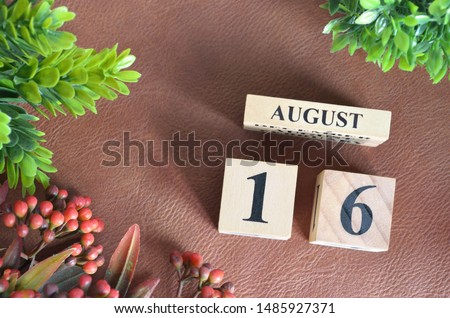 August 16. Number cube in natural concept on leather for the background