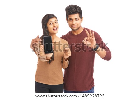 Beautiful happy young couple showing smart phone 