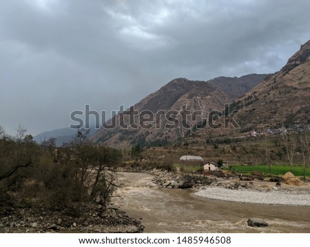 Shimla landscape in monsoon weather, Mountains of himachal pradesh,river flows in forest , mountains are in behind , clouds touch pick of the mountains, stones on river