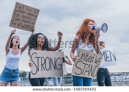 multicultural girls holding placards and screaming outside 