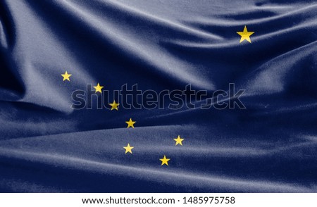 Realistic flag State of Alaska on the wavy surface of fabric
