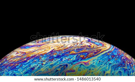 Close up picture of soap bubble on black background like planet abstract multicolor psychedelic globe 