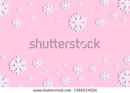 Christmas or winter composition of snowflakes on pastel pink background.