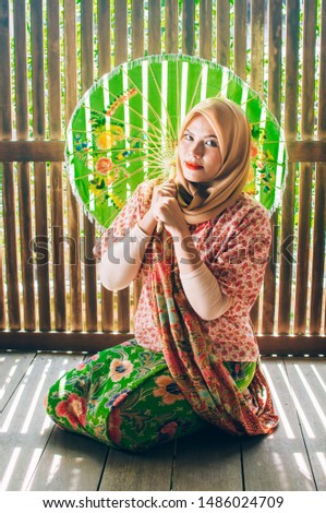 Portrait of pretty young asian muslim woman with Malay traditional outfit
