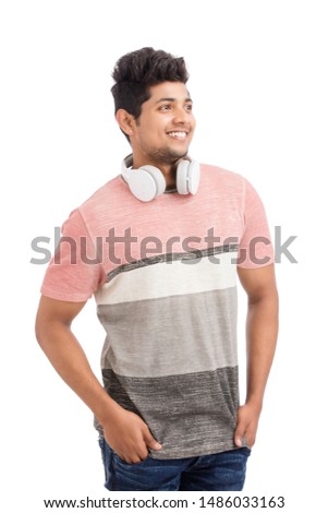 Handsome young Indian man standing with headphones