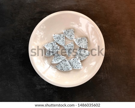 Piece of white dragon fruit on plate on wood background.Health menu.