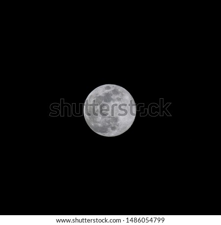Picture taken on a night day. It is a close-up to the full moon. The contrasts and colors of the moon are very well appreciated.